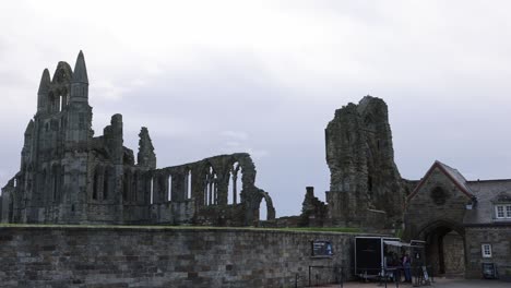 Langsame-Schwenkaufnahme-Von-Touristen,-Die-Eintrittskarten-Für-Den-Eintritt-Und-Die-Erkundung-Der-Whitby-Abbey-Kaufen