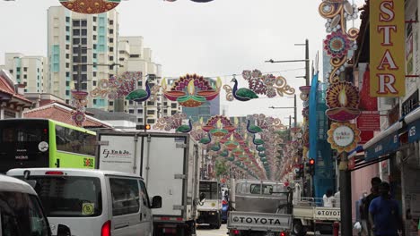 Tráfico-Intenso-A-Lo-Largo-De-Serangoon-Road-En-Little-India-Con-Decoraciones-De-Diwali-Colgando-Entre-Farolas-Durante-El-Día