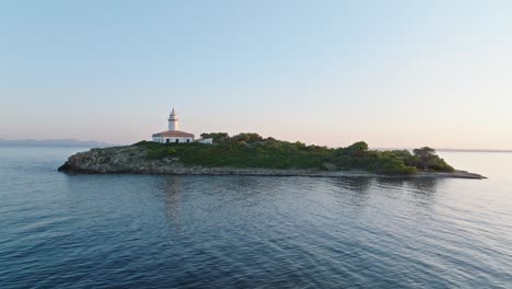 Drone-orbits-around-serene-Alcanada-lighthouse-over-calm-ocean-reflection