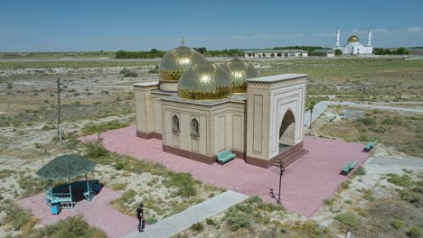 Mazars-Antiguos-Y-Nuevos-En-El-Mausoleo-De-Arystan-Bab-En-Kazajstán-Con-Mezquita-En-La-Distancia