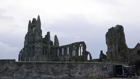 Schwenkaufnahme-Von-Touristen,-Die-Am-Ticketschalter-Der-Whitby-Abbey-Entlanggehen