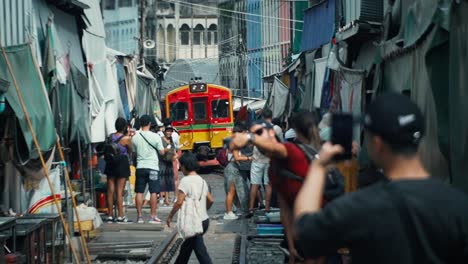 Zug-Kommt-Mit-Menschen-Und-Touristen-Am-Maeklong-Eisenbahnmarkt-An