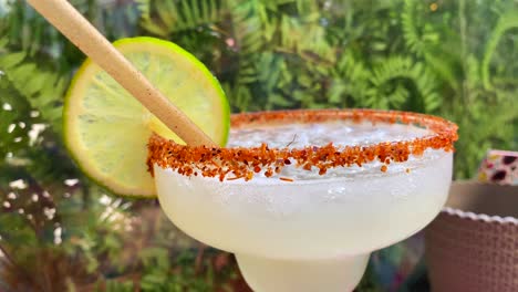 Spicy-margarita-mezcalita-cocktail-with-tajin-and-a-lime-slice-in-a-Mexican-restaurant,-famous-party-drink,-4K-shot