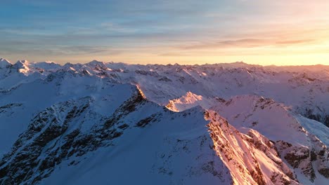 Drone-footage-of-the-South-Tyrolean-mountains-at-sunrise,-with-a-slight-glow-from-the-sun