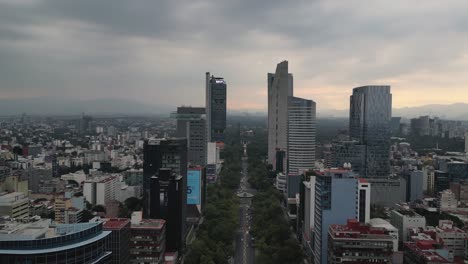 A-drone-video-showcasing-Reforma-Avenue,-its-buildings,-and-the-cityscape-of-Mexico-City