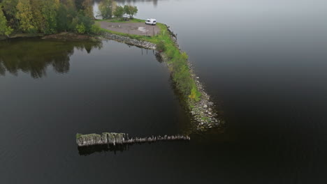 Aerial-Of-A-White-Van-Parked-At-The-Lakeshore-With-Calm-Black-Water-In-Sweden