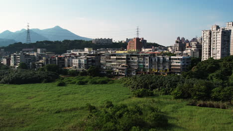 Antiguos-Edificios-De-Apartamentos-Y-Nuevas-Torres-De-Viviendas-Se-Alinean-En-Los-Humedales-De-Guandu-En-El-Distrito-De-Beitou,-Taipei.