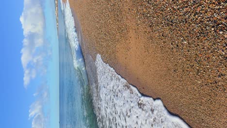 sandy-beach-and-small-stones-in-slow-motion-with-small-waves-in-vertical