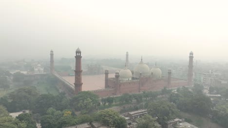 Vista-Aérea-De-La-Icónica-Mezquita-Badshahi-En-Lahore,-Pakistán,-A-Través-Del-Aire-Brumoso