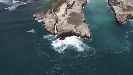 Aerial-view-of-waves-hitting-the-reef-seen-from-above,-located-on-Klayar-Beach,-Pacitan,-Indonesia