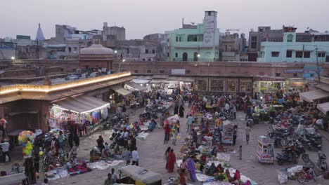 Gente-Caminando-En-La-Concurrida-Calle-Comercial-De-La-Ciudad-Por-La-Noche-Desde-Un-ángulo-Plano-El-Vídeo-Se-Toma-En-El-Mercado-De-Sardar-Ghantaghar-Jodhpur-Rajasthan-India-El-6-De-Noviembre-De-2023