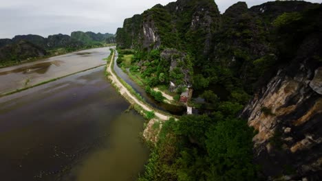 FPV-Drohne-Gleitet-über-überflutete-Reisfelder-In-Tamcoc,-Vietnam,-Und-Reflektiert-Den-Bewölkten-Himmel