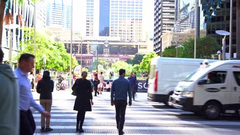 Office-workers-and-general-public-crossing-on-Queen-street-at-Post-office-square-with-central-station-at-the-background-during-rush-hours-at-Brisbane-central-business-district,-static-shot