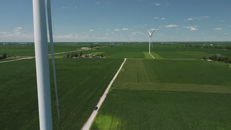 Wind-Farm---Aerial-View-Of-Green-Fields,-Crops,-Road-And-Wind-Turbines-In-The-Countryside