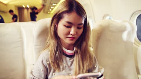 Asiatische-Frau-Benutzt-Mobiltelefon-Im-Flugzeug