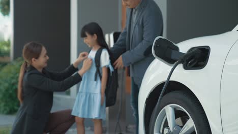 Progressive-young-parents-and-daughter-living-in-a-home-with-an-electric-car.
