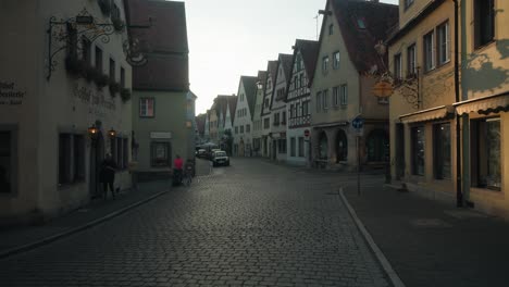 Golden-hour-light-shines-between-homes-onto-peaceful-empty-street-in-quaint-village