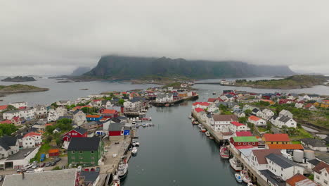 Waterway-lined-with-fishing-boats-docked-at-canal-in-Henningsvaer-village,-Lofoten-Norway