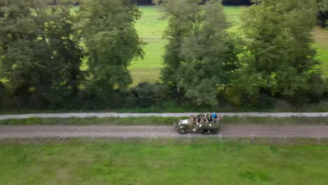 Aerial-sideways-green-American-world-war-two-half-track-drive-on-dutch-road