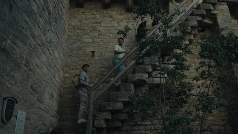 Group-of-friends-climb-up-cobblestone-pathway-exploring-scenic-sites-of-a-small-town