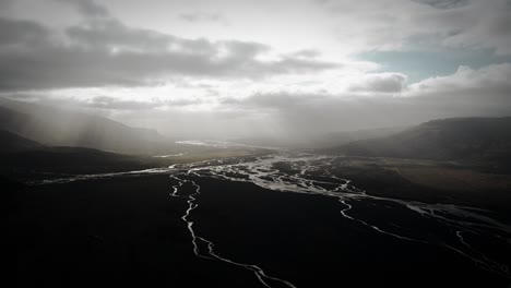aerial-thor-valley,-glacial-river-flowing-through-black-volcanic-floodplain,-thorsmörk-dramatic-scenery-moody-landscape-Iceland