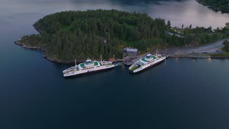 Ferry-leaves-from-Sognefjorden-pier-transporting-travelers-in-fjord,-Norway-aerial