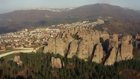 Aerial-view-of-the-Belogradchik-mountain-and-rock-formations,-a-grand-expanse-of-trees,-revealing-the-historic-fortress,-Rock-formation-Belogradchik