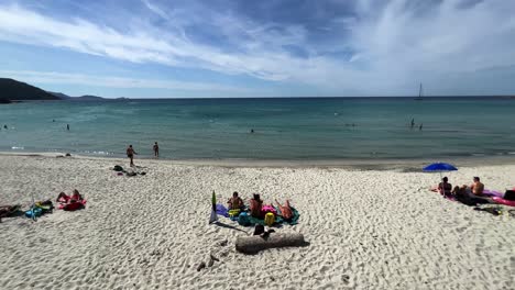People-bathing-and-sunbathing-on-sandy-Lotu-beach-in-summer-season,-Corsica-island-in-France