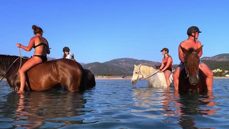 Tourists-ride-horses-without-saddle-and-with-swimwear-in-sea-water-in-summer-season