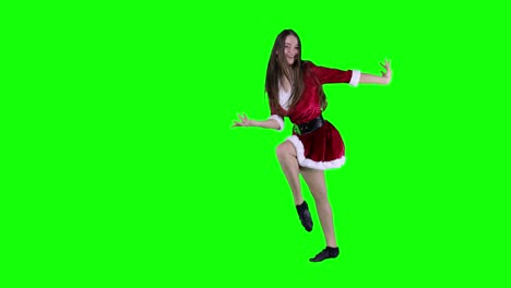 Springende-Frau-In-Den-Zwanzigern-In-Rotem-Weihnachtsmann-Weihnachtskleid,-Die-Tanzt,-Sich-Dreht-Und-Herumtanzt-Und-Spaß-Hat,-Ausdrucksstarke-Gestikulierende-Hände-Einzeln-Auf-Grünem-Hintergrundstudio
