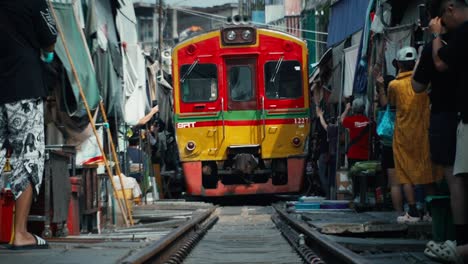 Slow-motion-train-travelling-on-railway-through-local-village-in-Asia