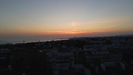 Von-Oben-Nach-Unten-Luftaufnahme-Des-Wunderschönen-Sonnenuntergangs-Und-Des-Meerblicks,-Überblick-über-Das-Stadtbild-Von-Lissabon