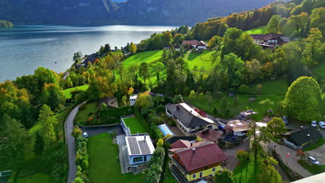 Aerial-view-tilting-toward-a-solar-powered-home,-fall-day-at-lake-Attersee,-Austria