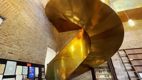 Tilt-up-of-bronze-plated-stairs-with-golden-sparkles-in-the-library-of-the-Pereira-Palace,-Santiago-Chile