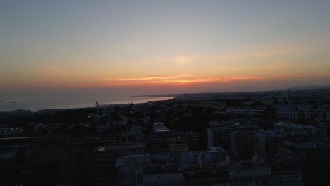 Scenic-aerial-view-of-sunset-with-a-view-on-the-atlantic-ocean-and-the-urban-city-of-Lisbon,-Portugal