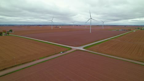 Aerial-crossroads-amidst-wind-turbines-and-plowed-fields-showcase-sustainable-rural-energy,-New-Sharon,-Iowa
