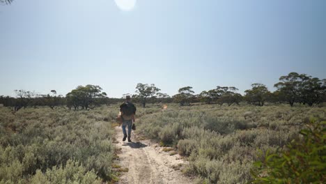 Ein-Swagman-Geht-Auf-Einem-Wüstenpfad-Durch-Das-Australische-Outback