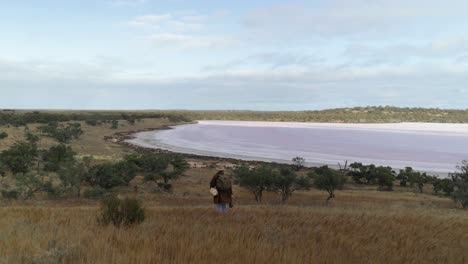A-swagman-walks-through-the-Australian-outback-past-a-salt-lake