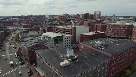 Flying-over-downtown-Portland-city-street-intersection-and-rooftops,-Maine