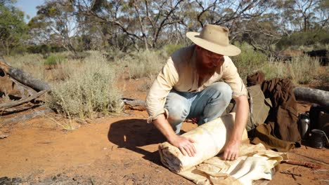 Ein-Australischer-Buschmann-Rollt-Seine-Authentische-Vintage-Ölhautbeute-Im-Outback-Aus