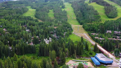 Aerial-pan-shot-of-slopes-and-the-Vail-town,-summer-day-in-Colorado,-USA