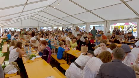 Juegos-Medievales-Del-Tirol-Del-Sur,-La-Gente-Se-Sienta-En-Una-Tienda-De-Comida