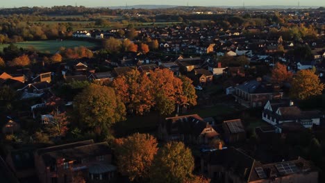 British-neighbourhood-housing-aerial-view-circling-early-morning-sunrise-autumn-coloured-rooftops