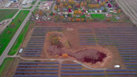 Aerial-of-solar-arrays-nestled-in-colorful-farmland,-merging-clean-energy-with-agricultural-heritage,-fall-in-Atwater,-MN,-USA