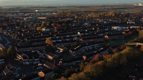 British-suburban-neighbourhood-housing-aerial-view-over-early-morning-sunrise-autumn-coloured-rooftops