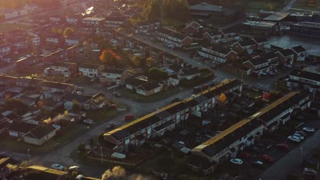 UK-Halton-townhouse-estate-aerial-view-with-early-morning-sunrise-light-leaks-over-Autumn-coloured-trees-and-rooftops