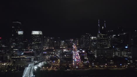 Sideview-aerial-of-skyskrappers-in-Nashville,-Tennesse-at-night