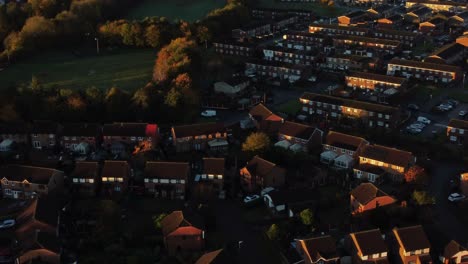 British-neighbourhood-housing-aerial-tilt-up-view-over-early-morning-sunrise-autumn-coloured-rooftops