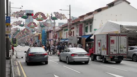 Der-Verkehr-Stoppt-Am-Fußgängerüberweg-Entlang-Der-Serangoon-Road-In-Little-India-Mit-Diwali-Dekorationen,-Die-Tagsüber-Zwischen-Laternenpfählen-Hängen