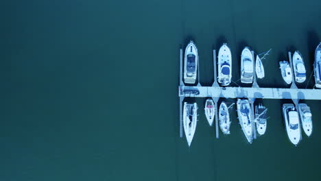 Aerial-straight-down-shot-of-luxury-motorboats-and-speedboats-parking-at-jetty-of-Marina